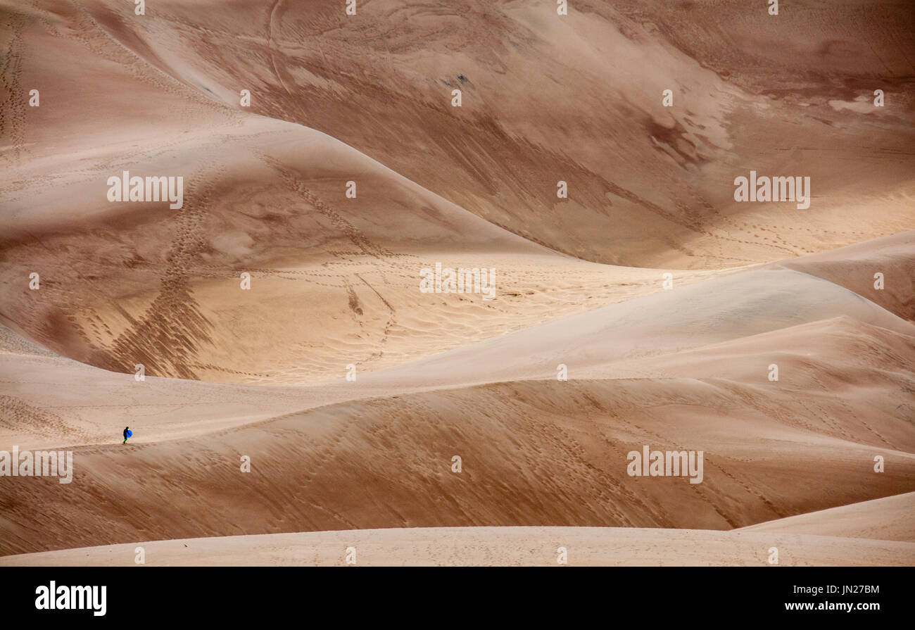 Man walking across the great sand dunes in Colorado, US Stock Photo