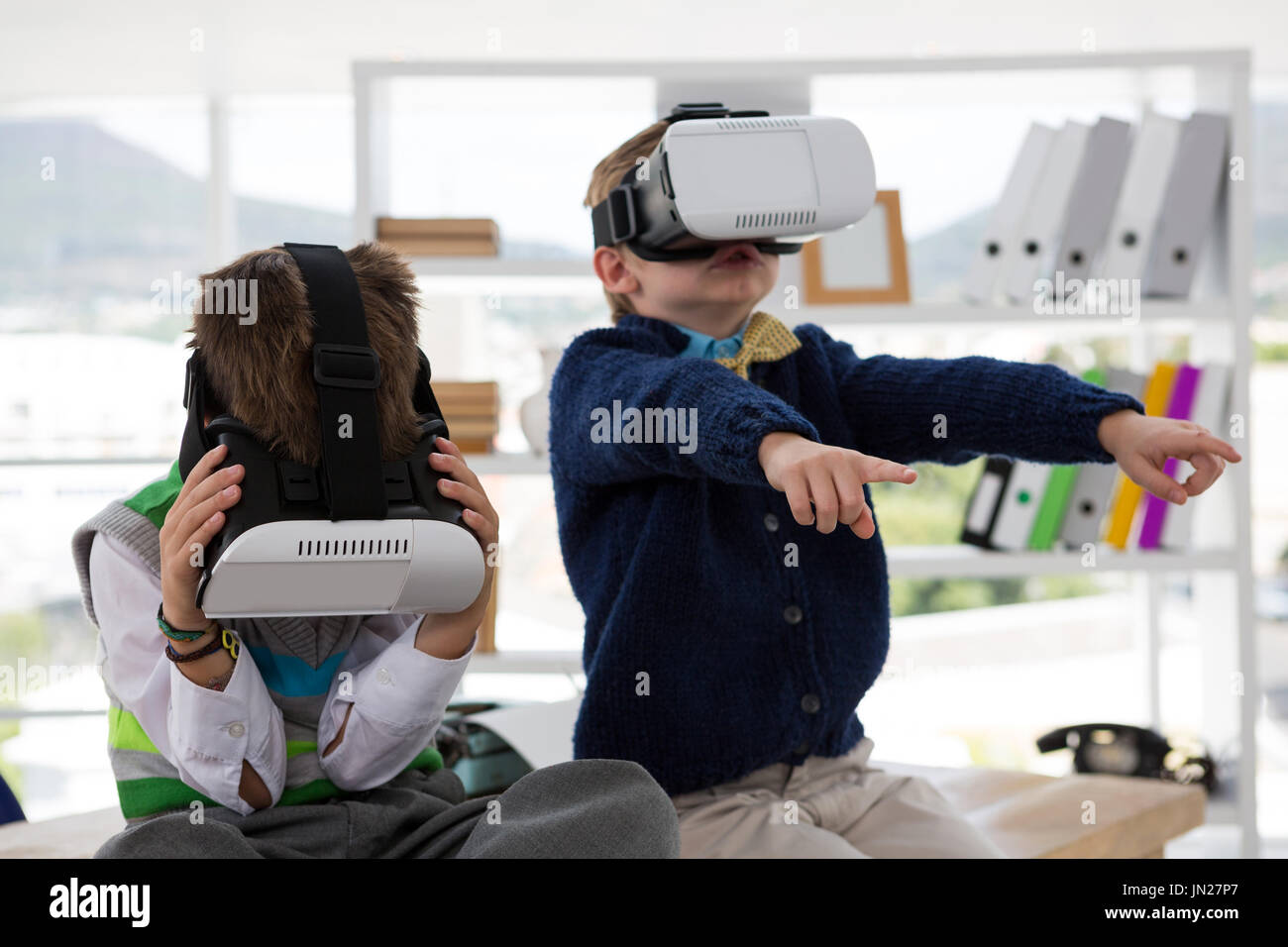 Kids as business executives using virtual reality headset in office Stock Photo