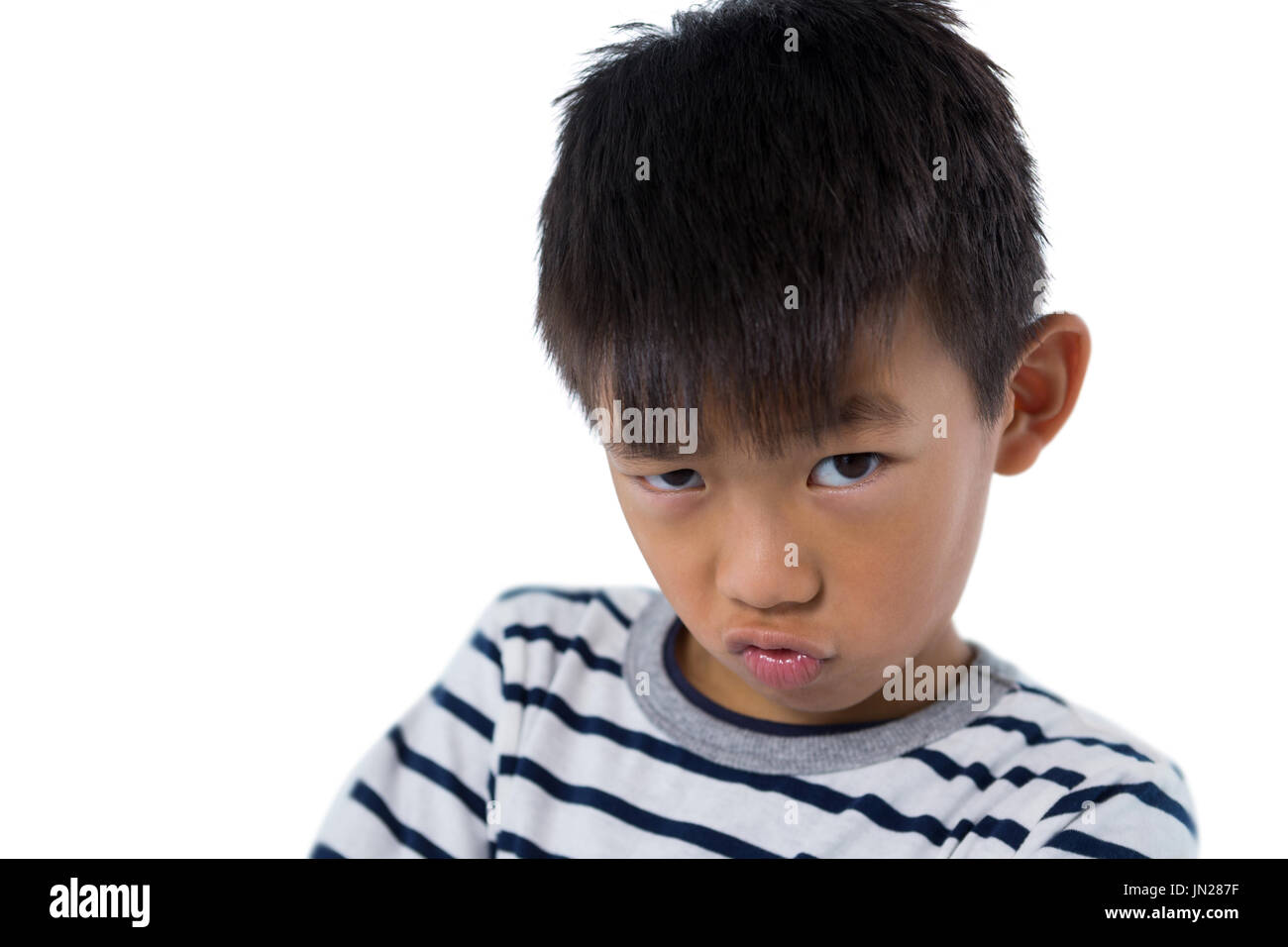 Portrait of boy sanding against white background Stock Photo