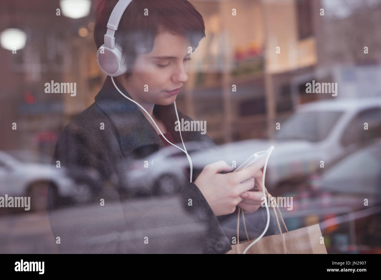 Young woman using mobile phone in store Stock Photo