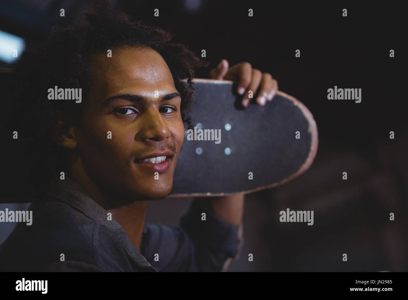 Portrait of man holding skateboard Stock Photo