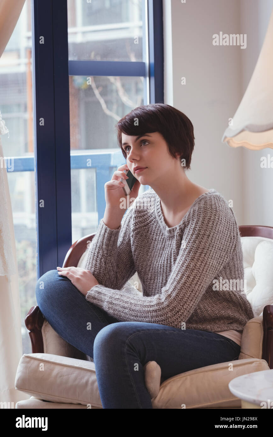 Young woman talking on mobile phone at home Stock Photo