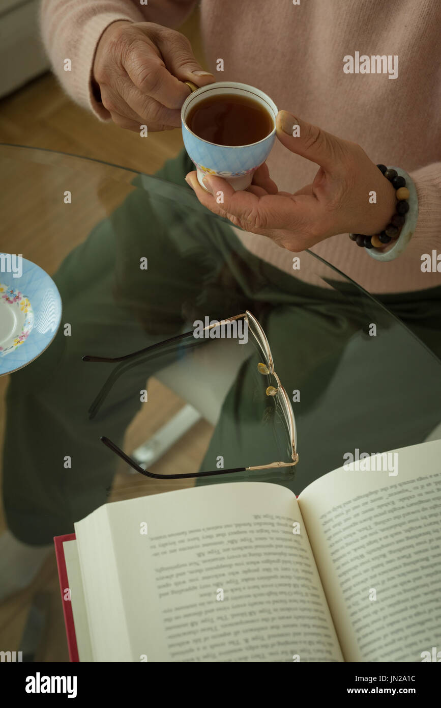 High angle view senior woman having tea while sitting at home Stock Photo