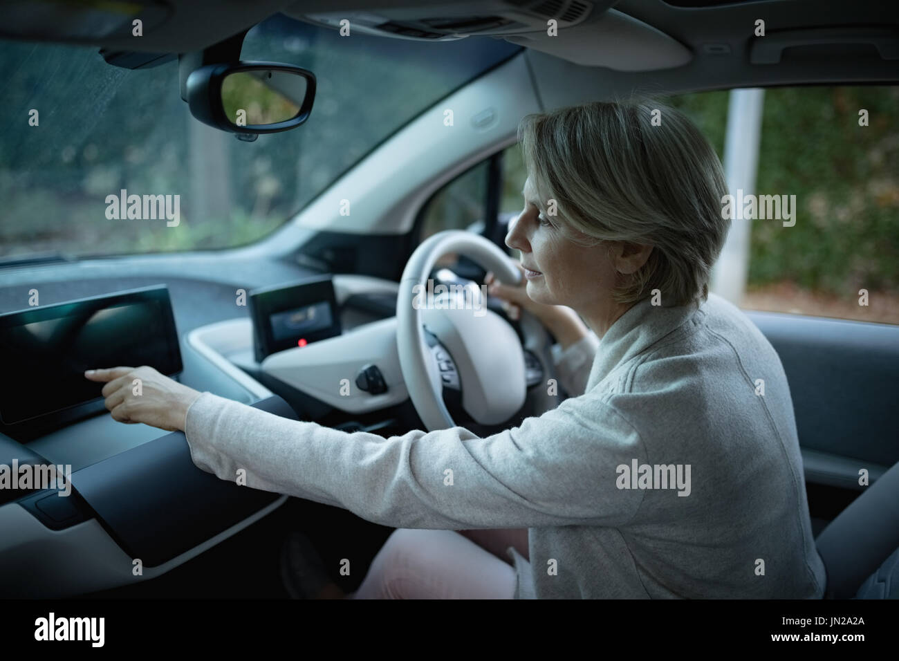 Side view of woman using digital tablet while driving car Stock Photo