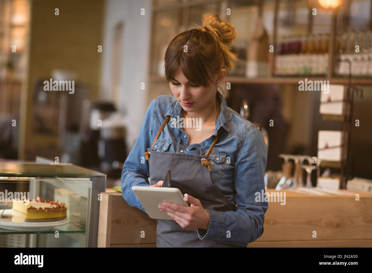 Waitress using digital tablet in cafÃƒÂ© Stock Photo
