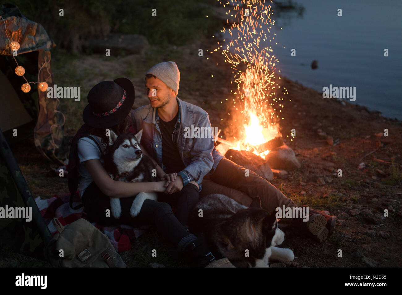 Couple looking at each other with dogs tent nature Stock Photo