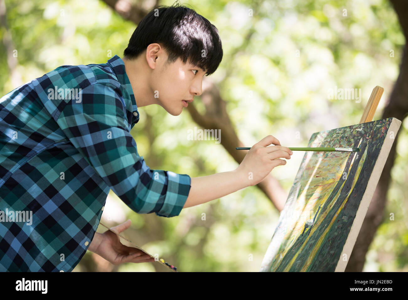 Young man painting outdoors Stock Photo