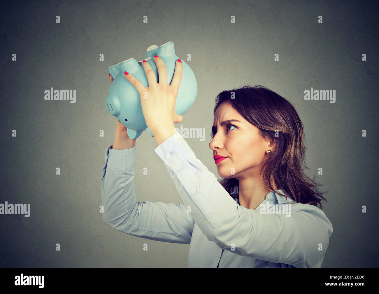Young worried woman with empty piggy bank Stock Photo