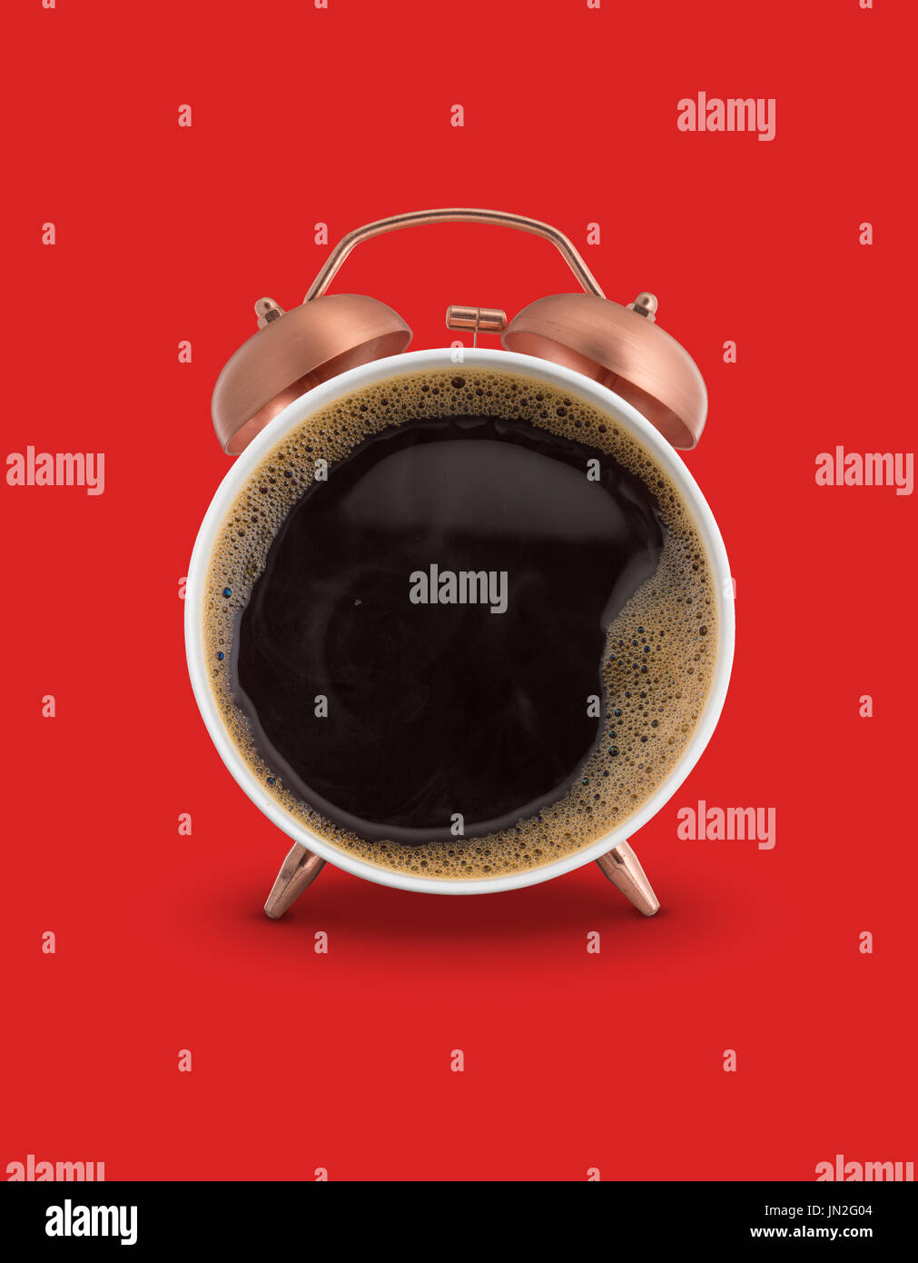 Twin bell alarm clock with coffee mug red background Stock Photo
