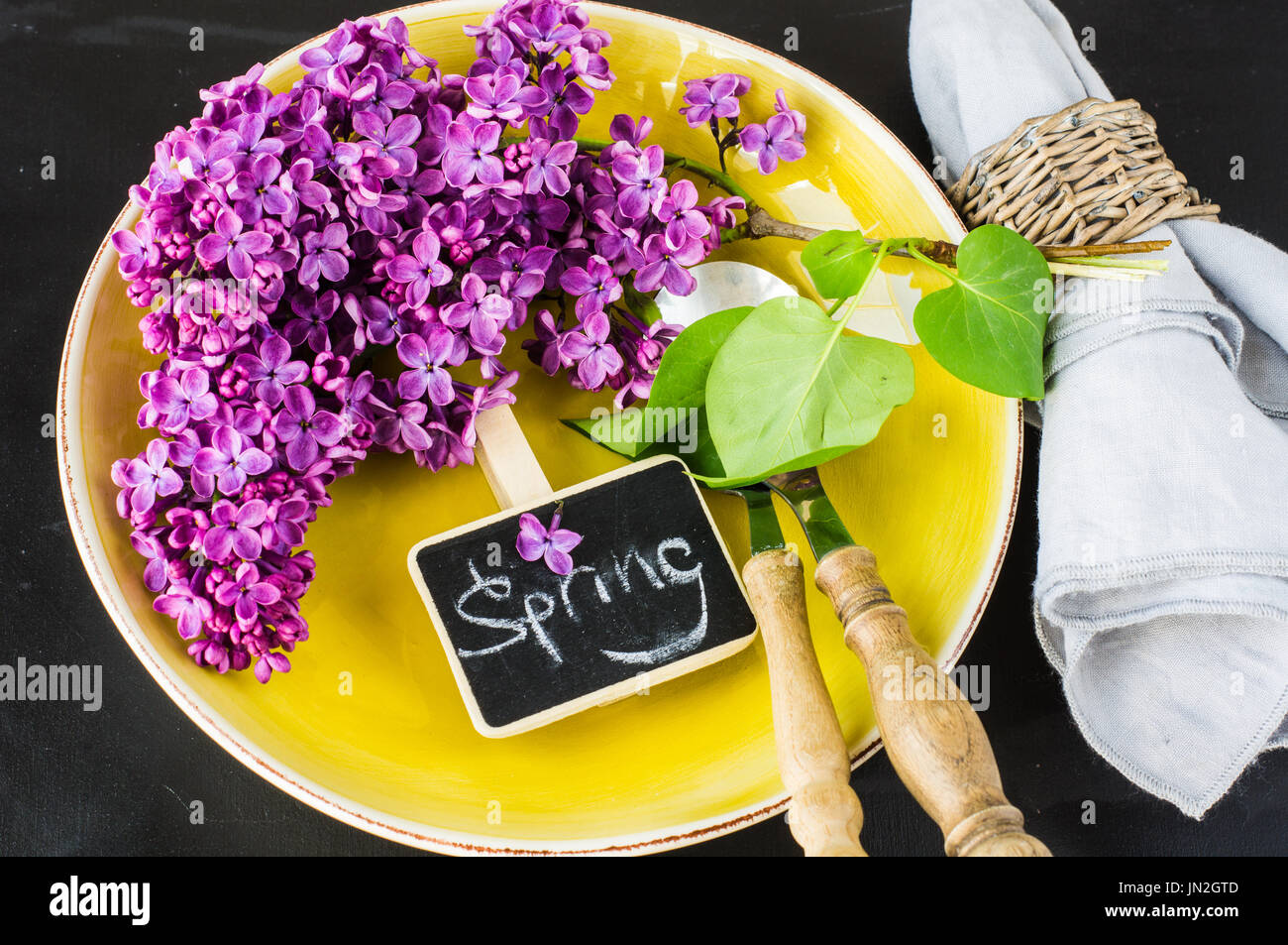 Spring table setting with bright lilac flowers on rustic background ...