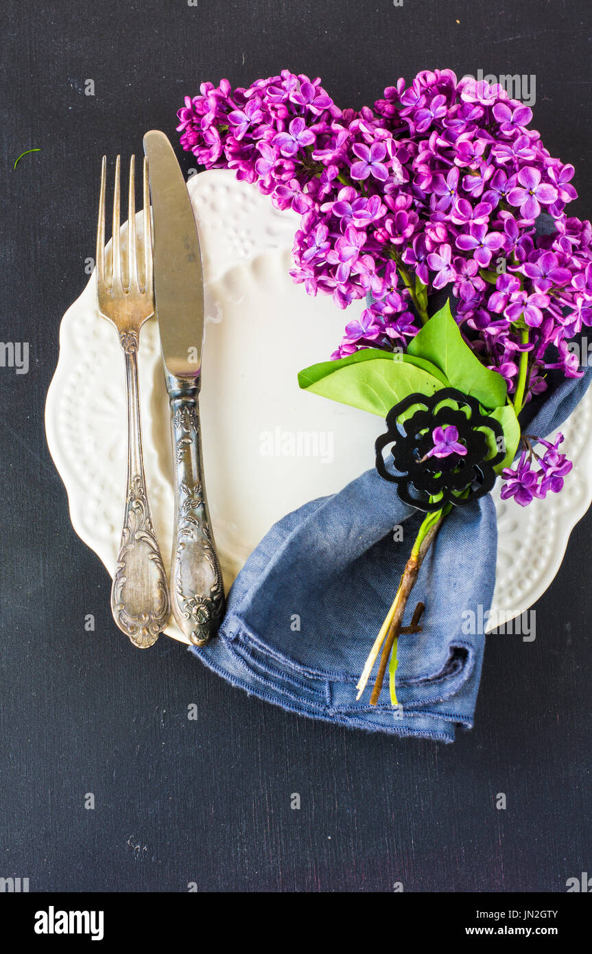 Spring table setting with bright lilac flowers on rustic background ...