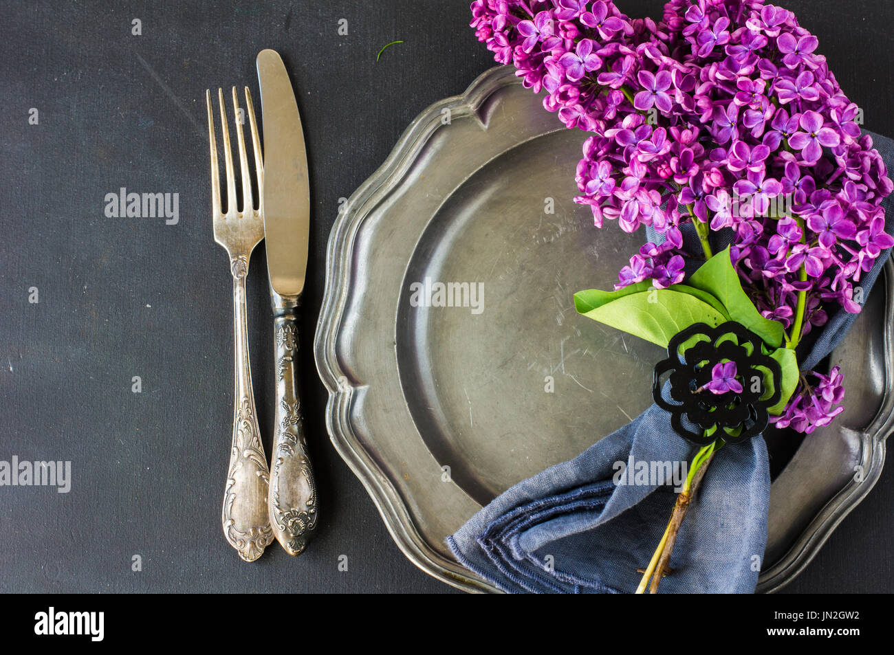 Spring table setting with bright lilac flowers on rustic background ...