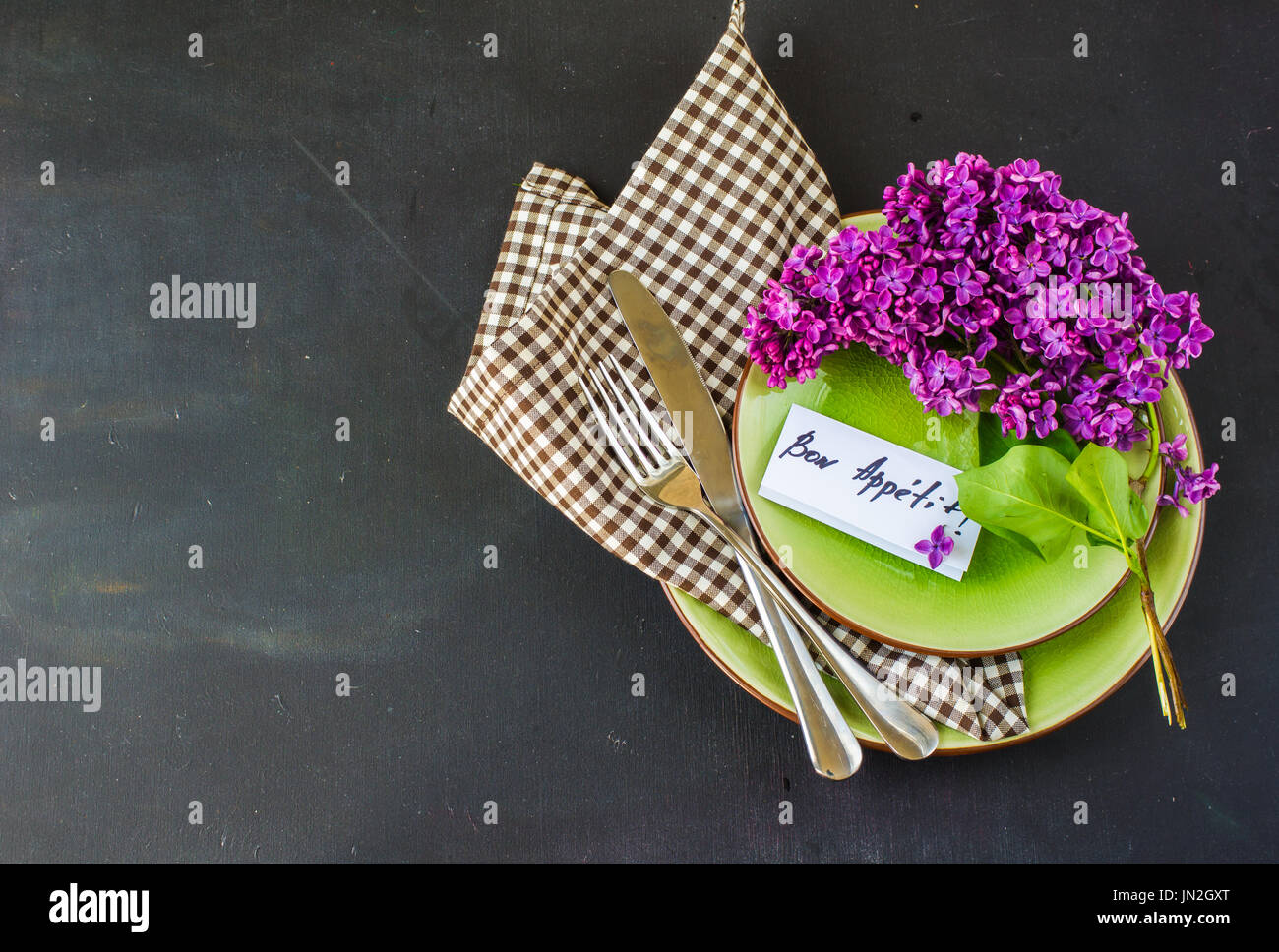 Spring table setting with bright lilac flowers on rustic background ...