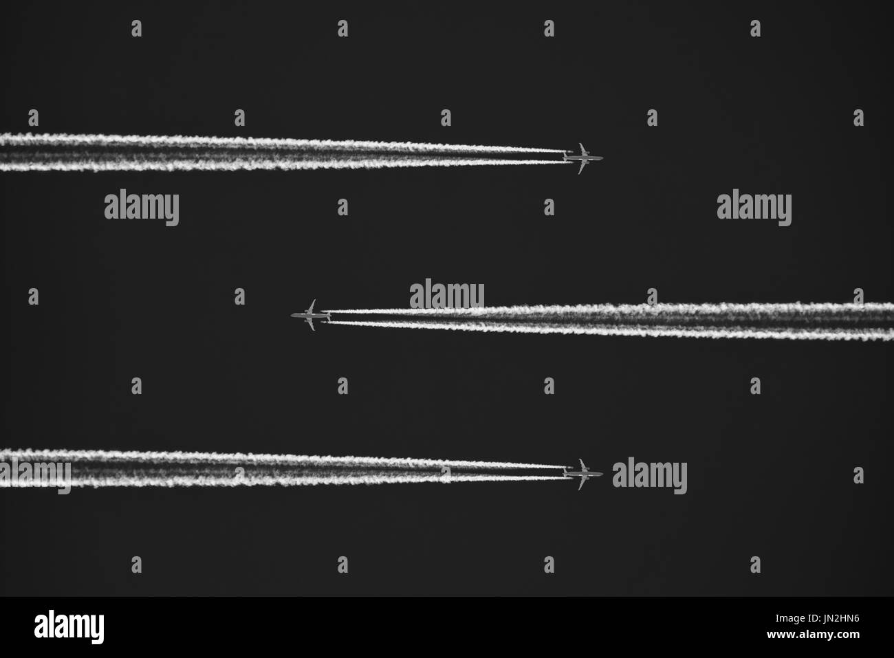 Black and white Image of three aeroplanes / airplanes high in the sky with visible vapor / vapour trails. credit: LEE RAMSDEN / ALAMY Stock Photo
