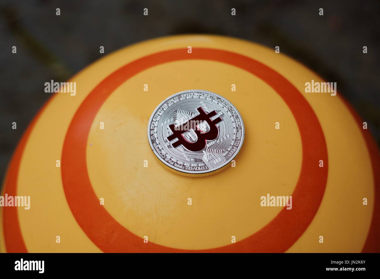 Digital currency physical red bitcoin coin on yellow circle background Stock Photo - Alamy