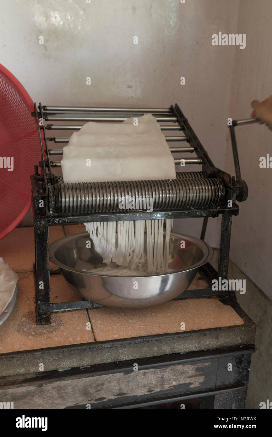 Rice noodles being made by hand with a manual cutting machine in rural Vietnam Stock Photo