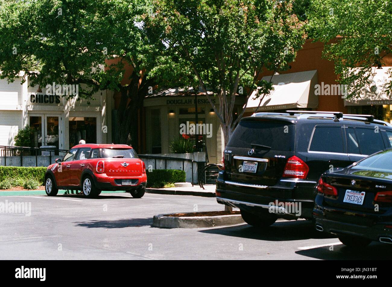 Luxury vehicles, including a Mercedes Benz SUV and BMW sedan, are seen parked in a shopping center in the affluent San Francisco Bay Area suburb of Lafayette, California, June 19, 2017. Stock Photo
