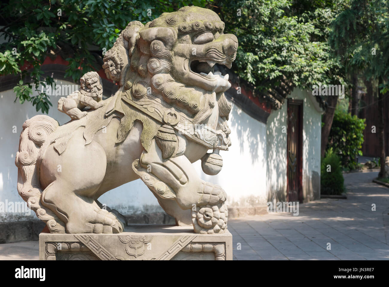 Lion stone statue with two small lions on the back in a park, Chengdu, Sichuan Province, China Stock Photo