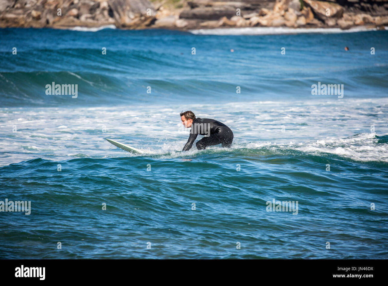Australian man enjoying surfing on a Sydney beach in Australia Stock Photo
