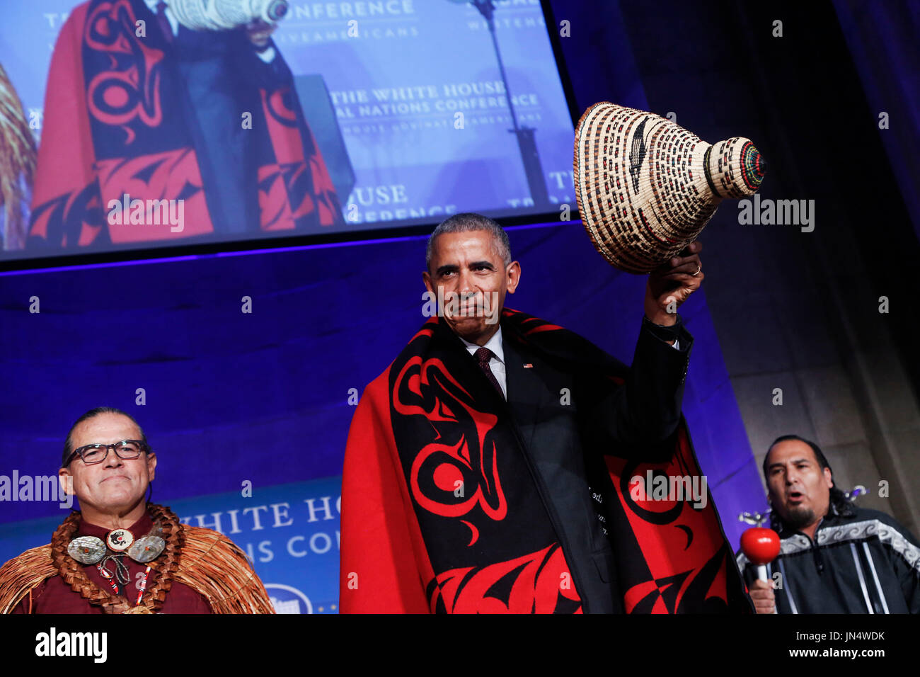 US President Barack Obama receives a traditional blanket and hat during