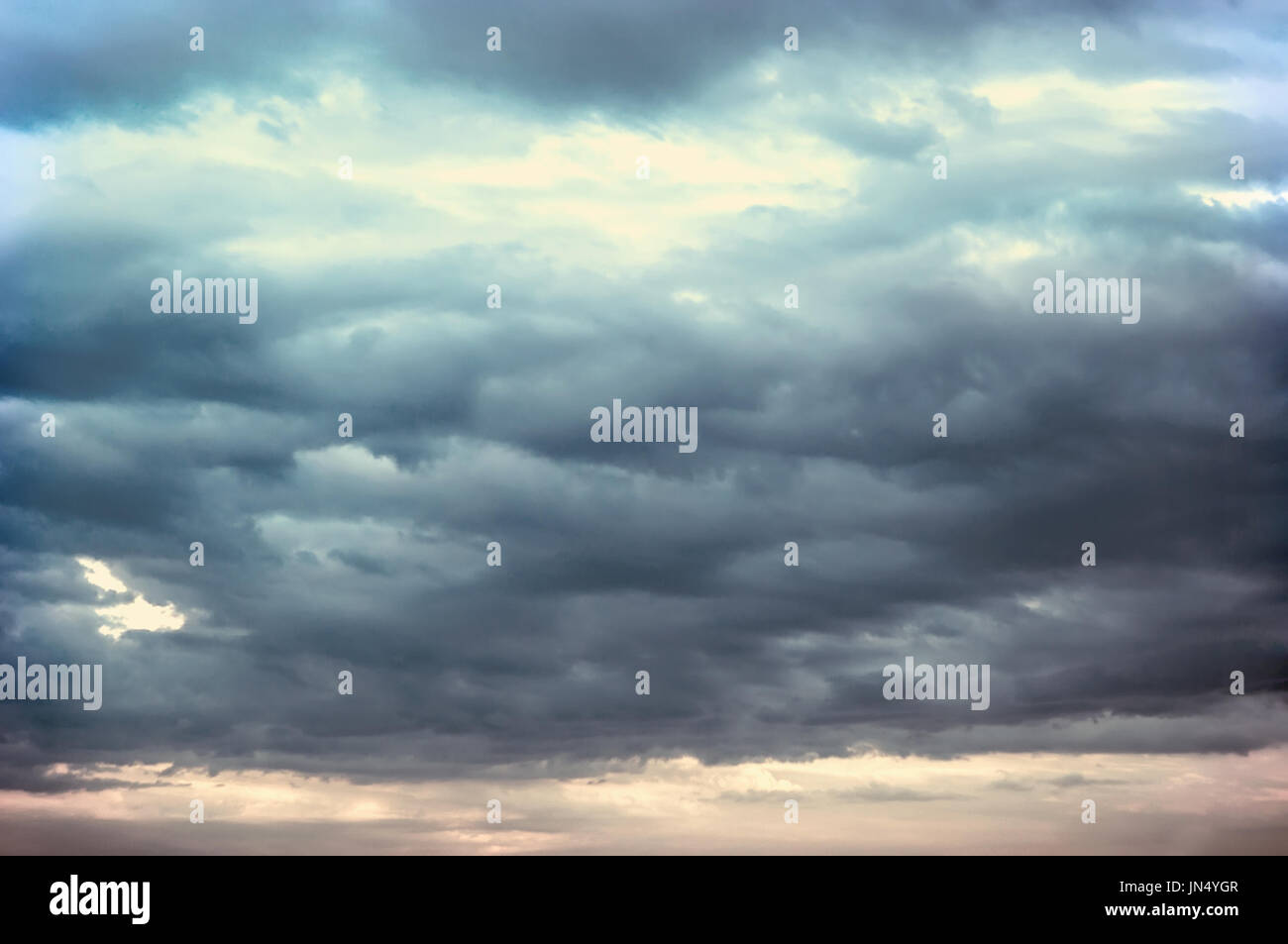 Background of dark clouds before a thunder-storm. Storm clouds in the dark sky. The dark background of bad weather. Stock Photo