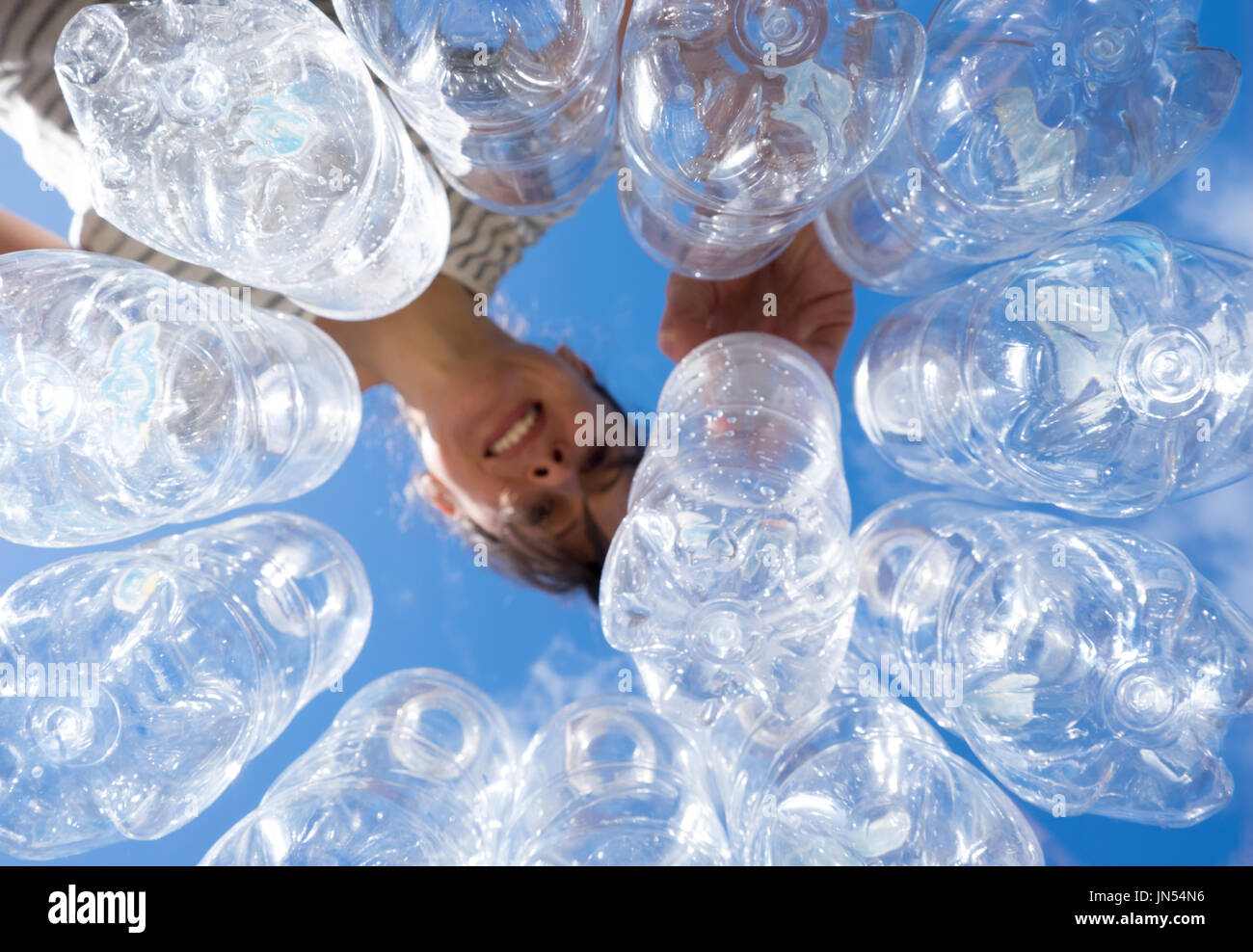 Smiling woman recycling plastic water bottles looking up POV in New Zealand, NZ Stock Photo Alamy