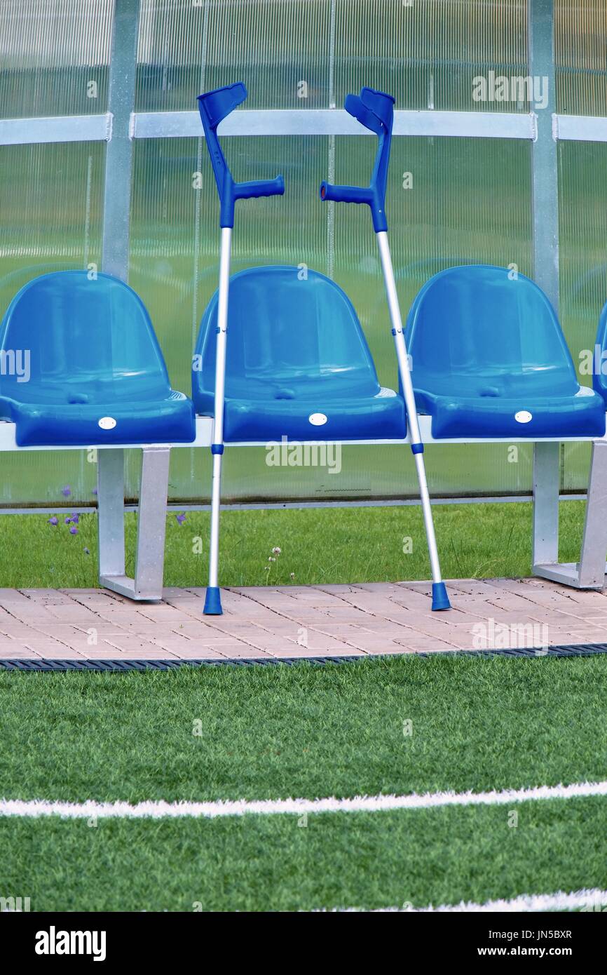 Crutch At Blue Plastic Seats On Outdoor Stadium Players Bench