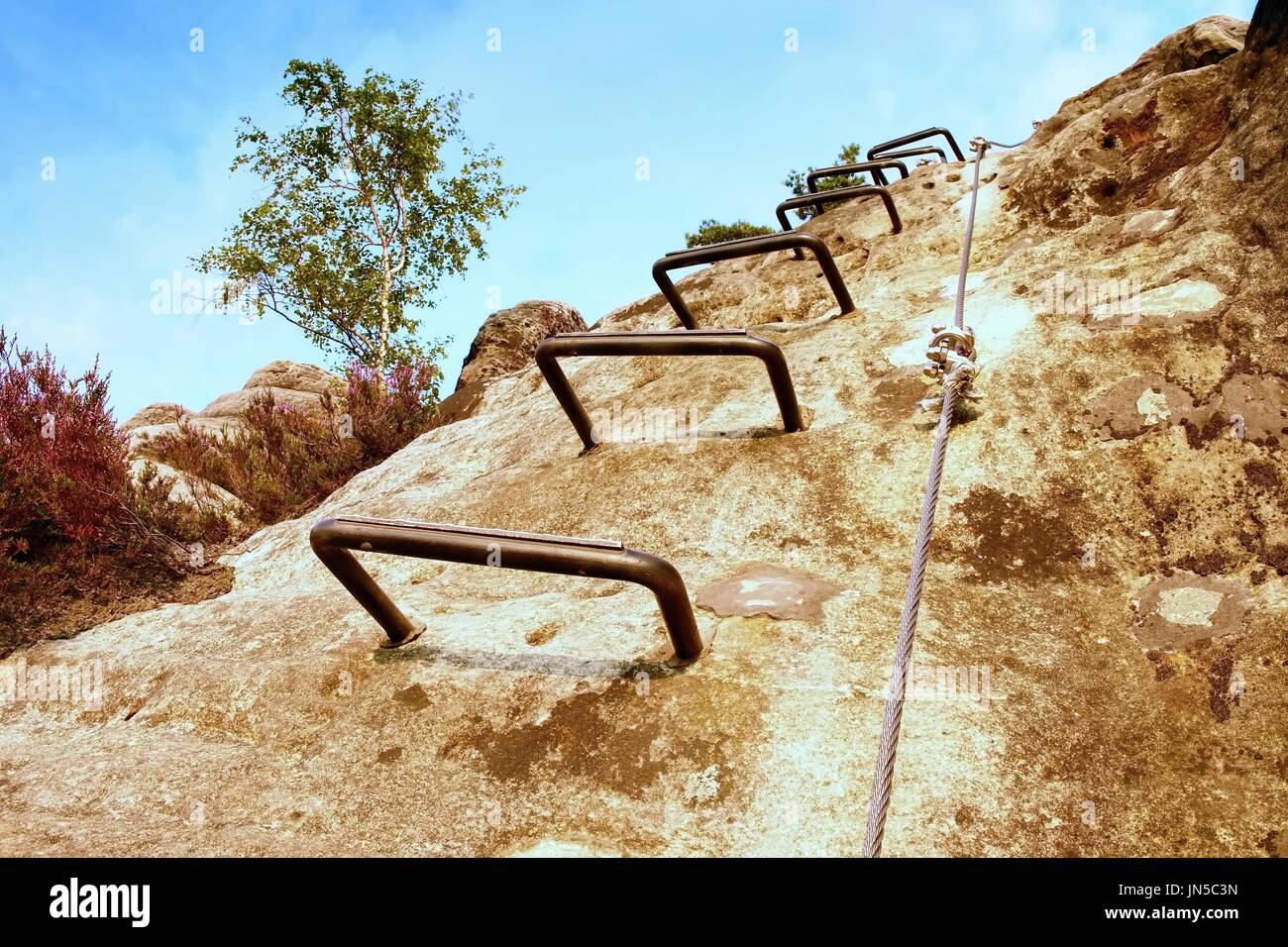 Climbers ladder. Iron twisted rope fixed in block by screws snap hooks