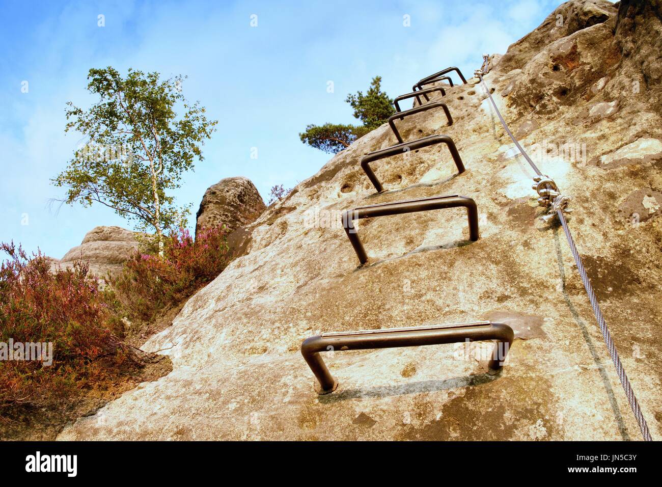 Climbers ladder. Iron twisted rope fixed in block by screws snap hooks