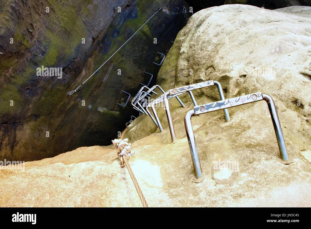 Climbers ladder. Iron twisted rope fixed in block by screws snap hooks