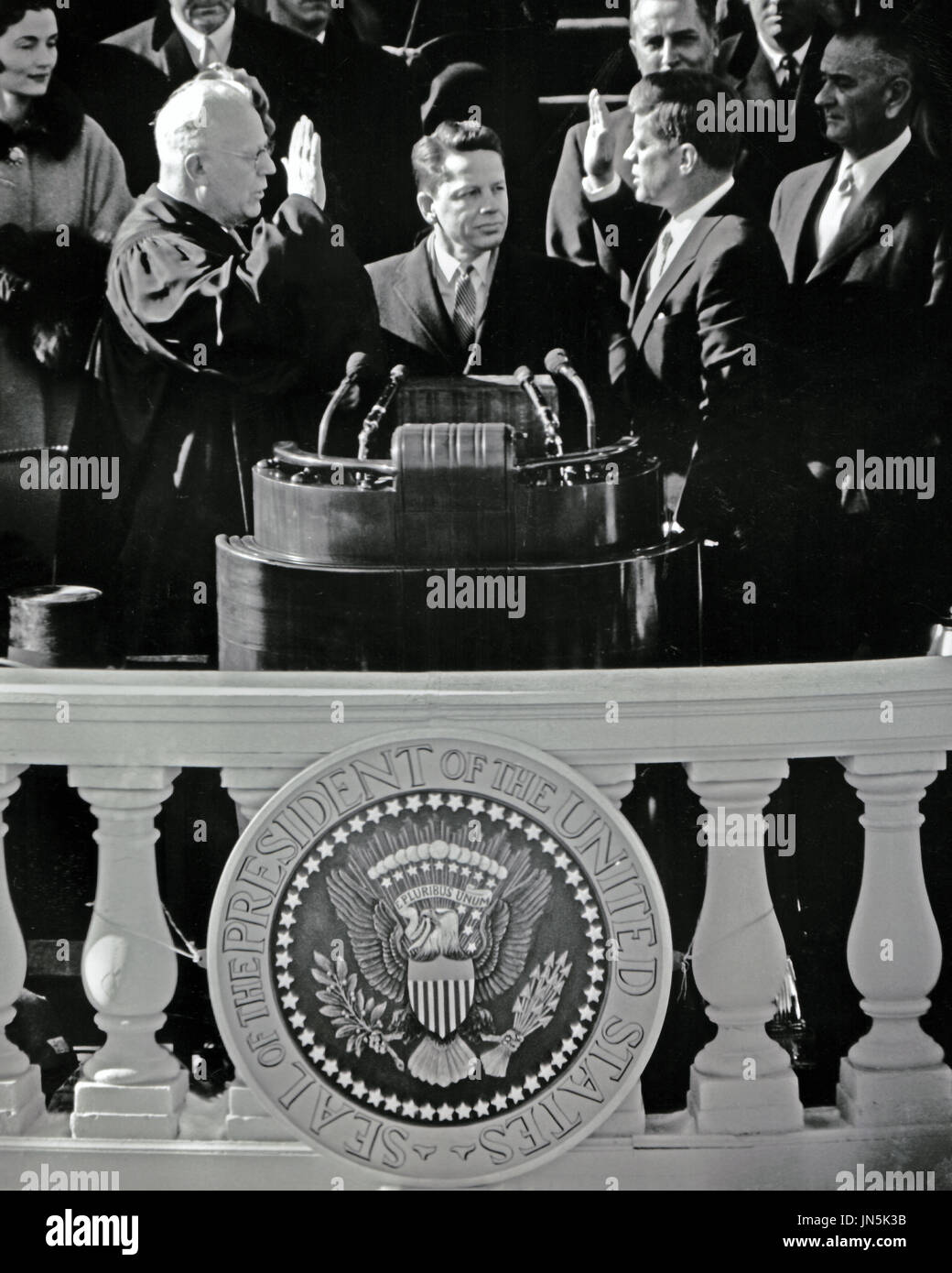 United States President John F. Kennedy is sworn-in as the 35th President of the United States by Chief Justice of the United States Earl Warren, left, on the East Front of the U.S. Capitol in Washington, D.C. on Friday, January 20, 1961..Credit: Arnie Sachs / CNP Stock Photo