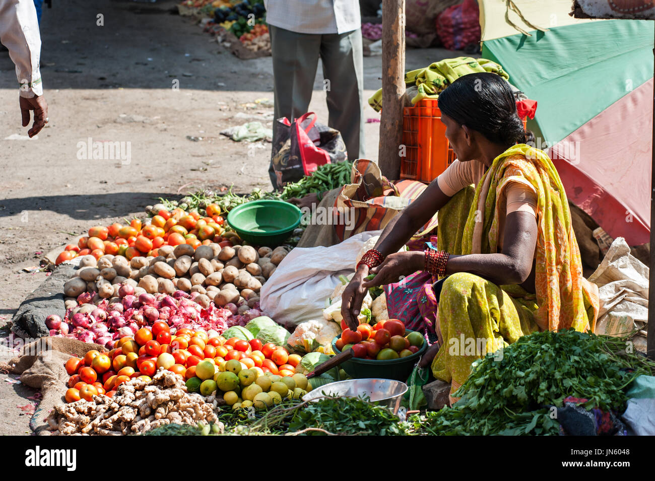 The colorful of fresh open air Gulmandi local market. Woman selling vergetables on street side walk. This is one of the largest bazaars in Aurangabad. Stock Photo