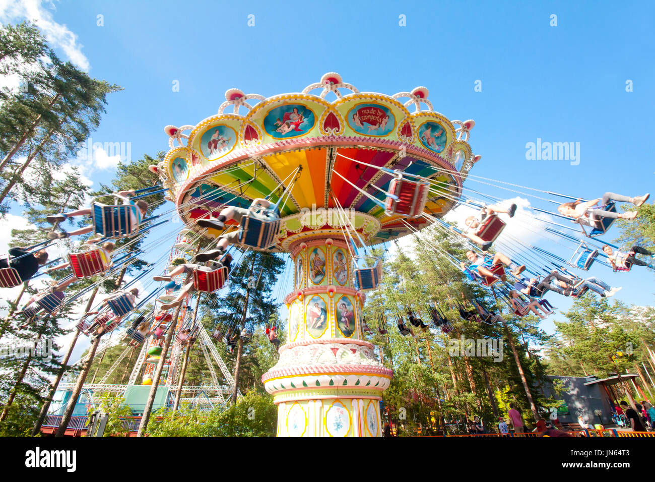 Colorful chain swing carousel in motion at amusement park on blue sky ...