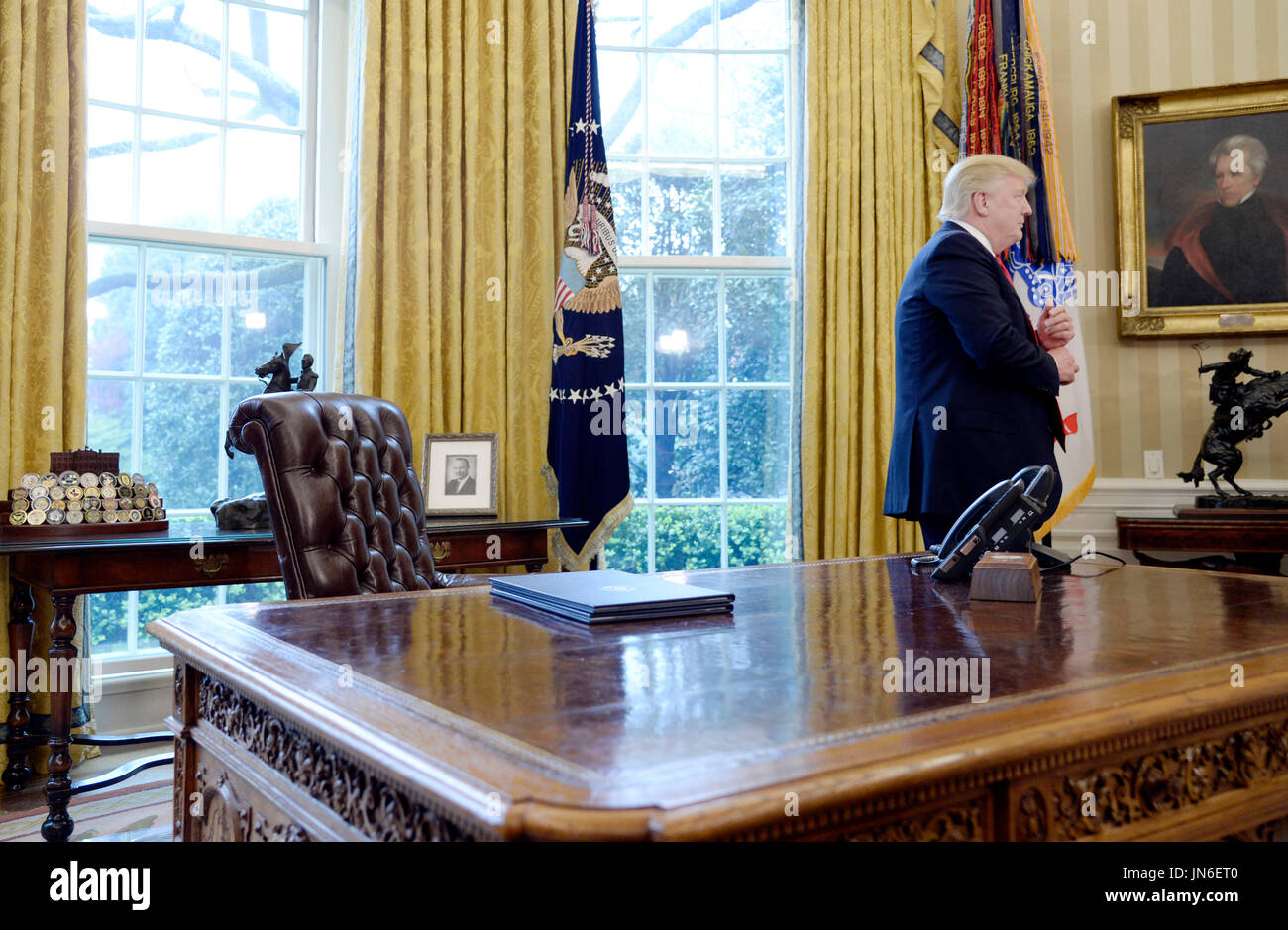 United States President Donald Trump stands in the Oval Office after