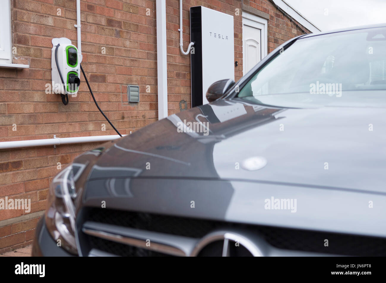 A Mercedes C class Hybrid electric car being charged ( via a Rolec charger) from solar PV stored in a Tesla Powerwall 2, a 14kWh battery.  All done fr Stock Photo