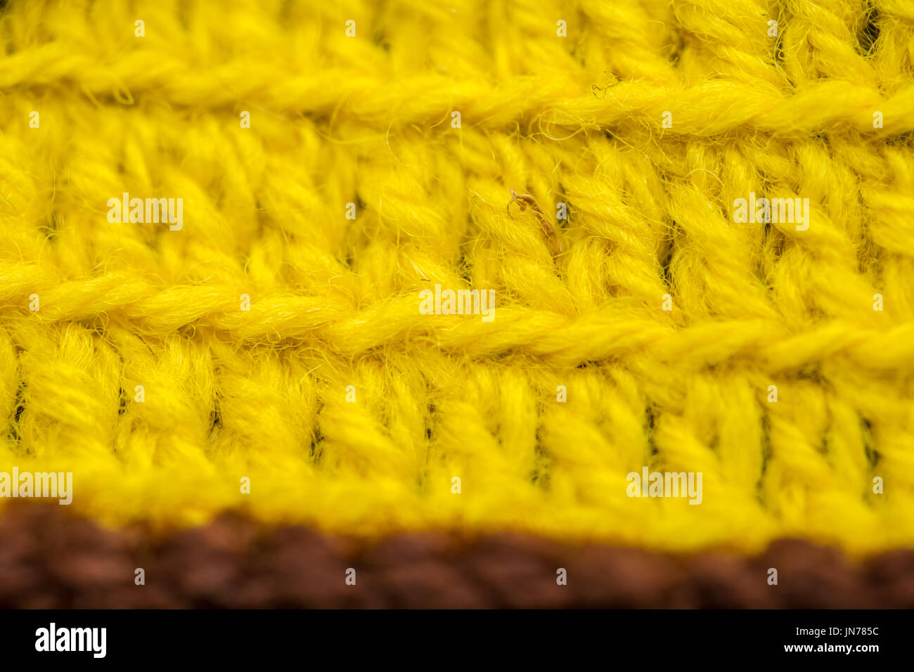 A beautiful closeup of a hand made crochet pattern of a colorful wool yarn. Soft and warm natural sheep wool. Pattern of wool. Stock Photo