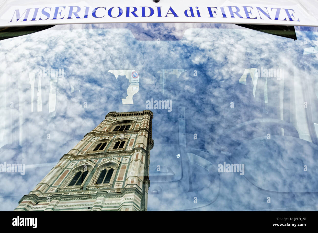 Florence, Italy - October 17, 2016: Giotto Bell Tower reflected in window of Servizi Sociali Misericordia di Firenze car, Florence, Tuscany, Italy Stock Photo