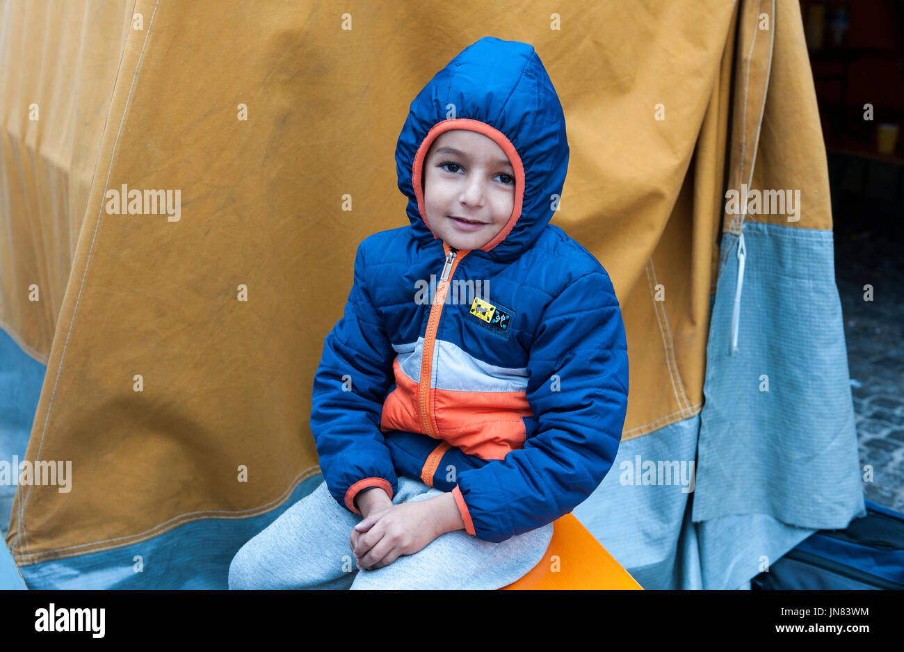 Munich, Germany -September 7th, 2015: Refugee child from Syria at Munich Central Station, Germany. Freezing and cold, but happy to be in safety. Stock Photo
