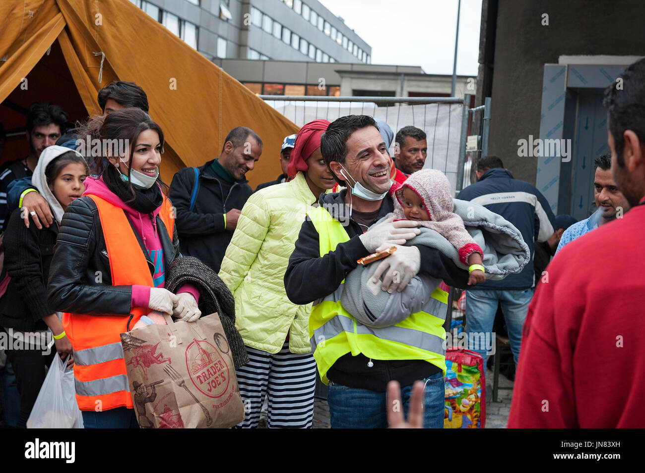 Munich, Germany -September 7th, 2015: A group of Syrian refugees with a small baby are very happy to arrive at the registration area in Munich. Stock Photo