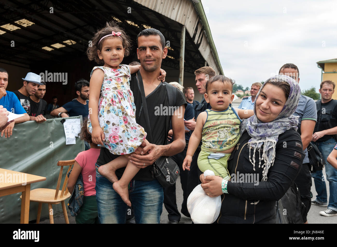 Passau, Germany - August 1st, 2015: Syrian refugee family at a registration camp in Passau, Germany. They are seeking asylum in Europe. Stock Photo