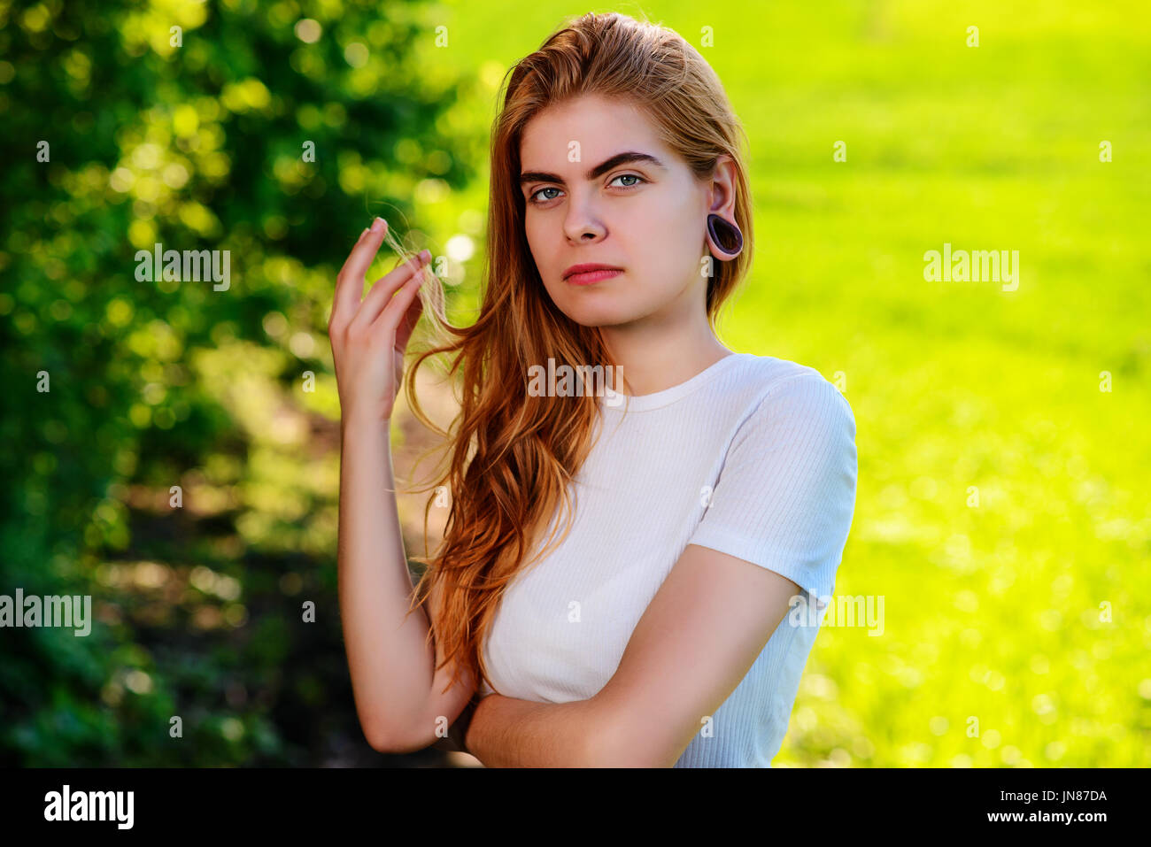 Portrait of a young beautiful woman with wooden tunnels in her ears