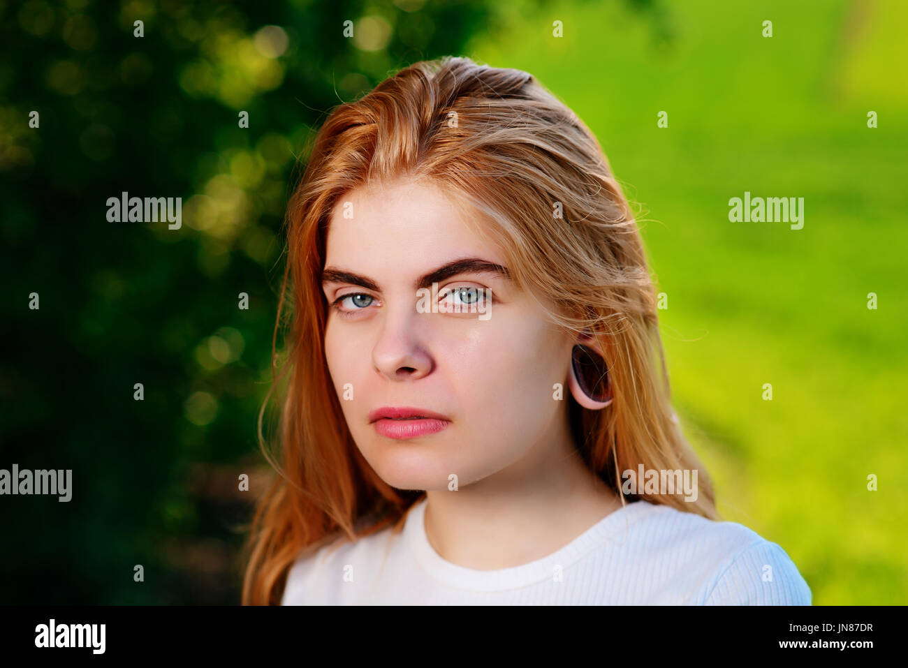 Portrait of a young beautiful woman with wooden tunnels in her ears
