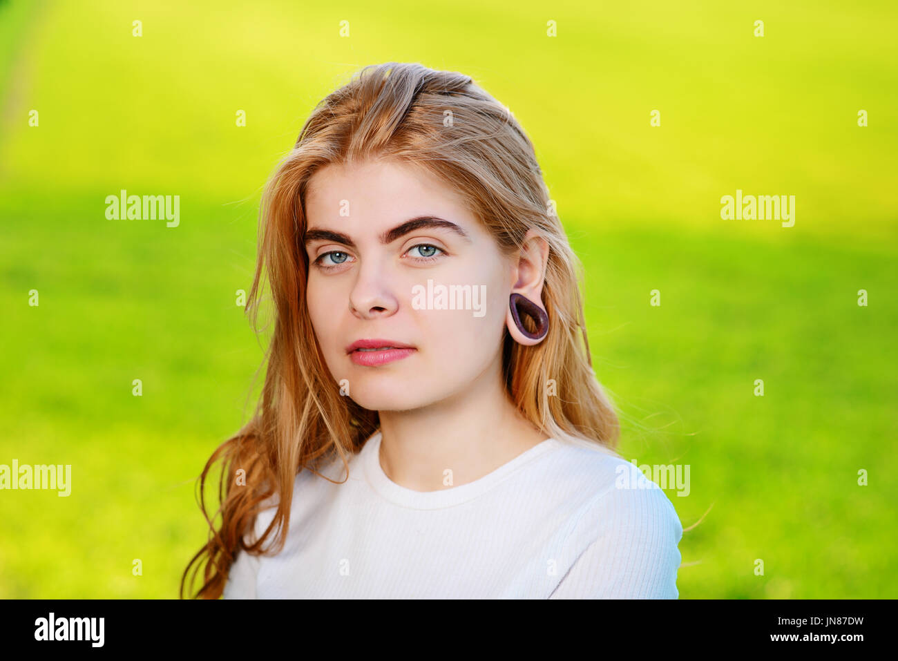 Portrait of a young beautiful woman with wooden tunnels in her ears