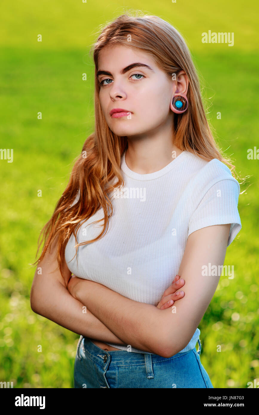 Portrait of a young beautiful woman with wooden tunnels in her ears