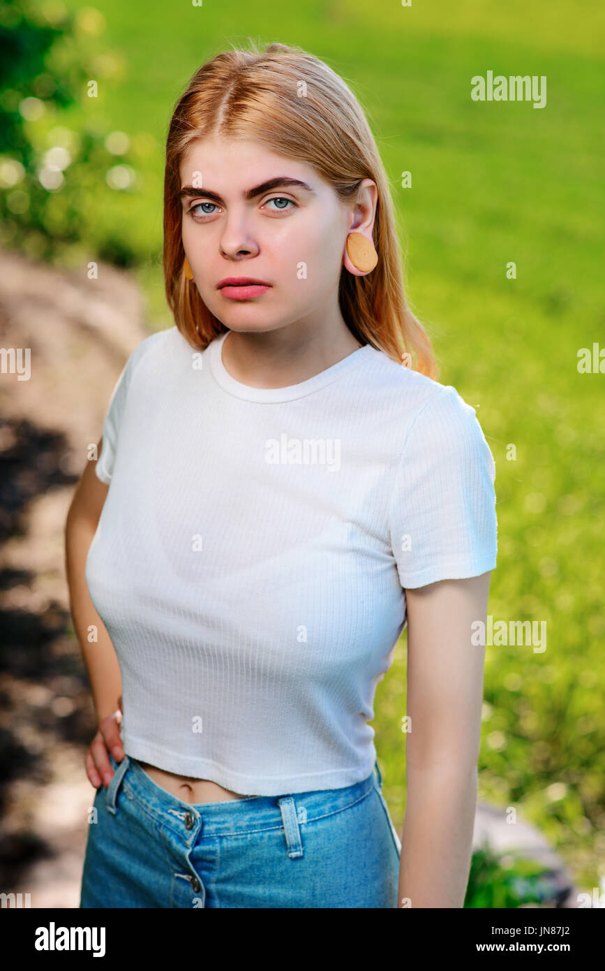 Portrait of a young beautiful woman with wooden tunnels in her ears