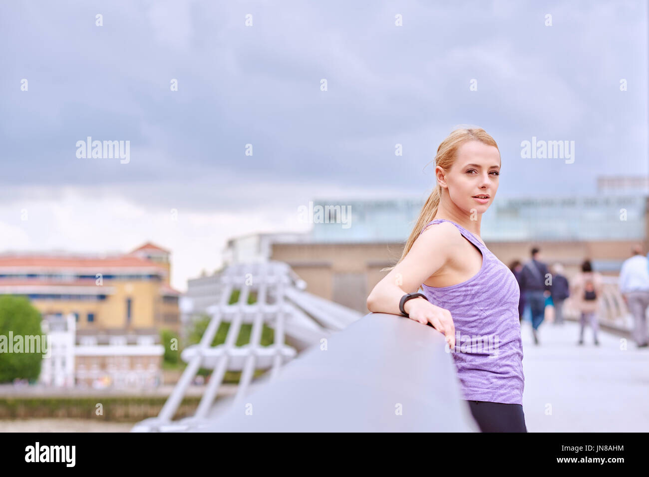 A young woman stops to relax while exercising in the City Stock Photo