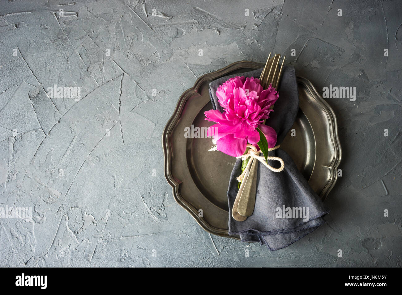 Summer table setting with bright peonies on dark rustic table with copyspace Stock Photo