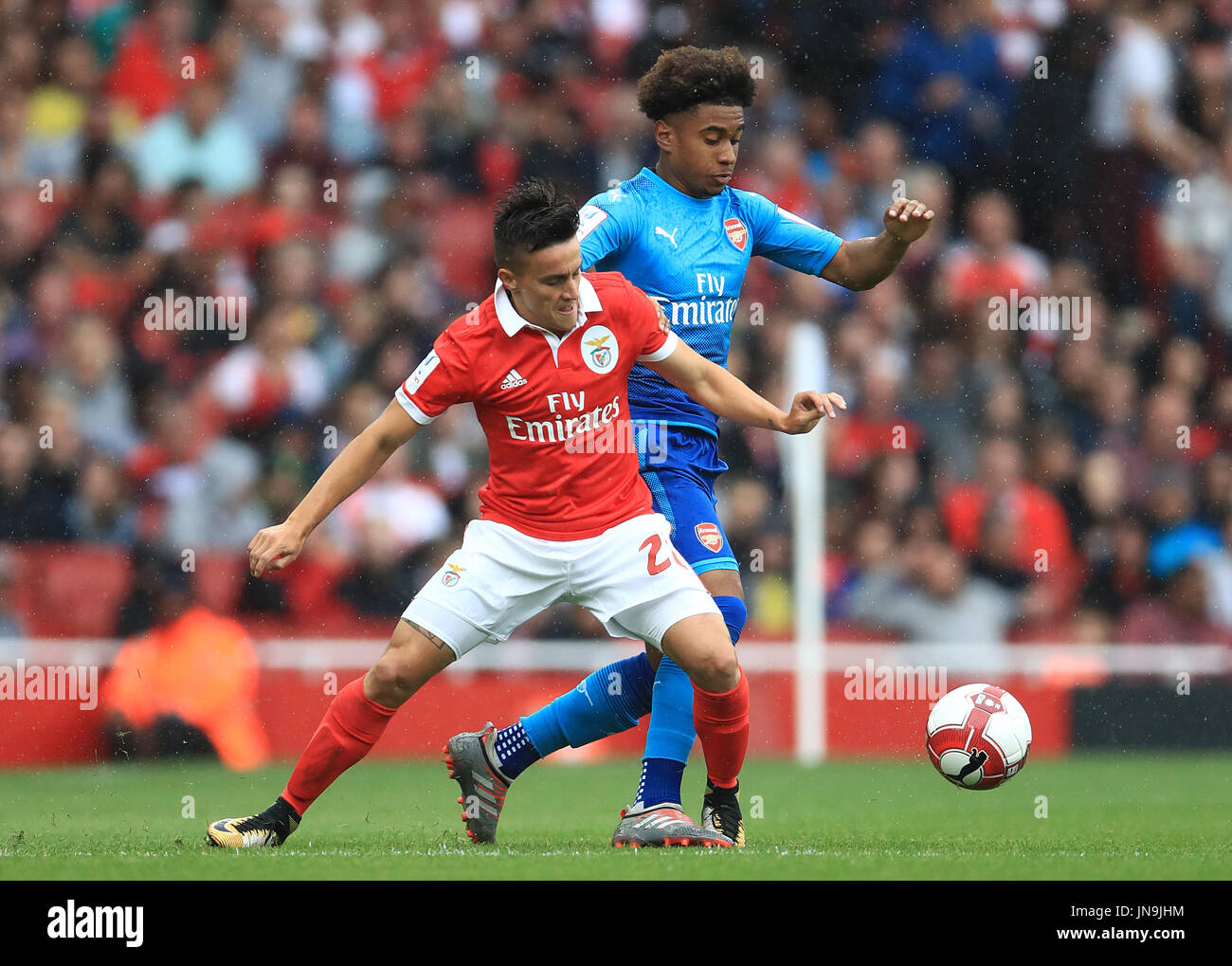 Benfica's Franco Cervi (left) and Arsenal's Reiss Nelson battle for the ball during the Emirates Cup match at the Emirates Stadium, London. Stock Photo