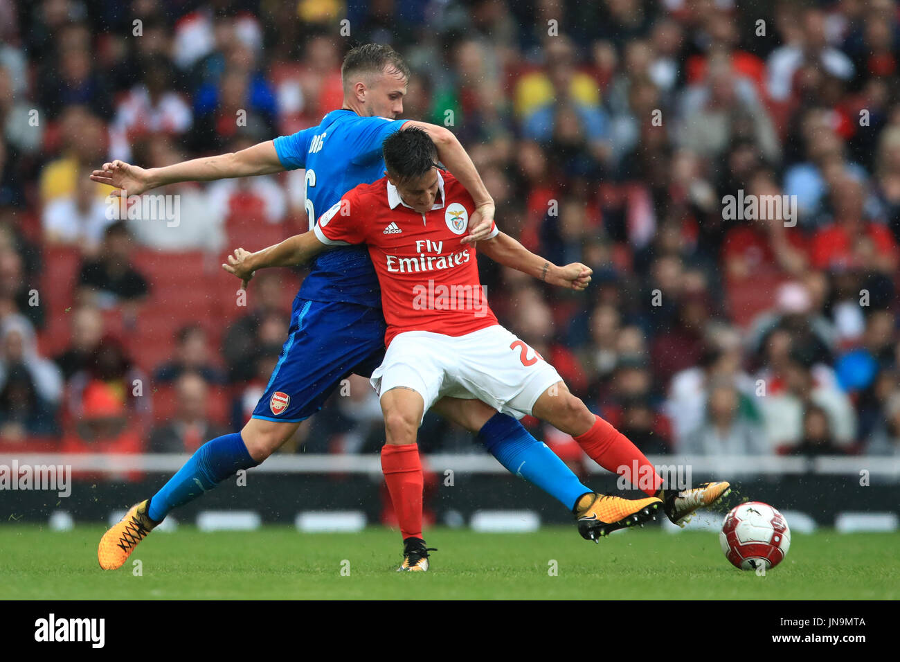Benfica's Franco Cervi (left) and Arsenal's Rob Holding battle for the ball during the Emirates Cup match at the Emirates Stadium, London. Stock Photo