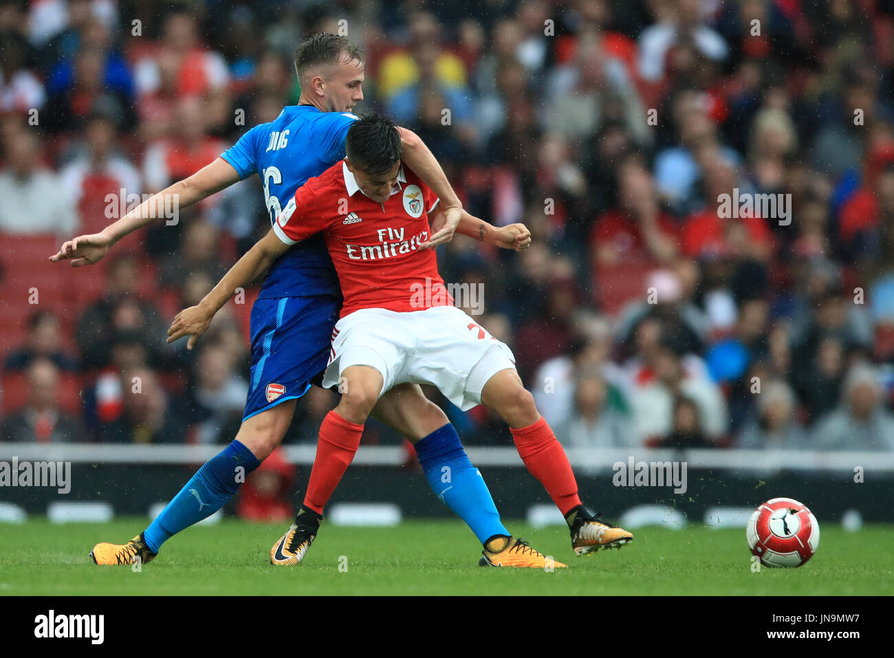 Benfica's Franco Cervi (left) and Arsenal's Rob Holding battle for the ball during the Emirates Cup match at the Emirates Stadium, London. Stock Photo